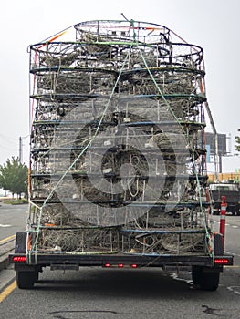 Stacks of crab pots carried on a trailer in traffic