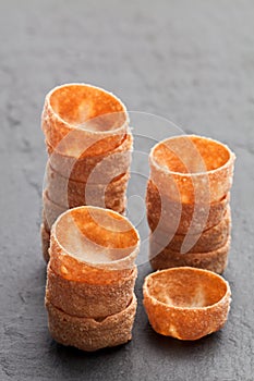 Stacks of croustades crispy pastry cases on black stone backgro