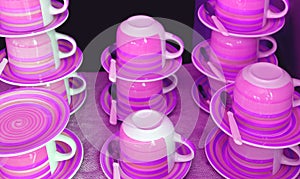 Stacks of cups and saucers in purple pink color tone