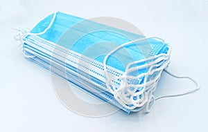 Stacks of disposable surgical masks or light blue colored new medical masks. COVID-19 prevention. H1N1, H5N1 safety measures.