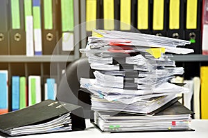 Stacks of document paper and files folder on office desk.