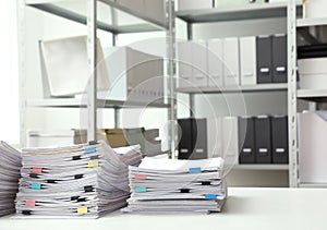 Stacks of documents with paper clips on office desk