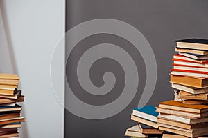 Stacks of educational books against the background of the wall in the library