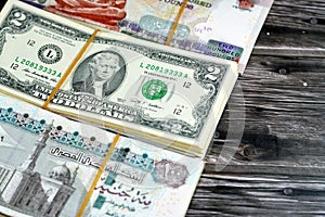 Stacks of Egyptian and American currency cash money banknotes with rubber bands of 2 two American dollars and 100 EGP , 200 LE one