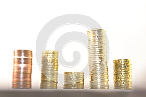 Stacks of gold coins of different levels, on a white background. Concept of financial growth success