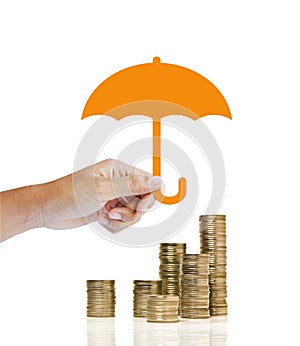 Stacks of golden coins covered by paper umbrella