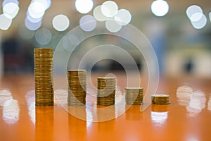 Stacks of golden coins like income graph, Five piles of coins in different positions, Thai currency with bokeh background, Concept