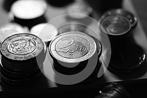 Stacks of iron euro coins on the table, bw photo