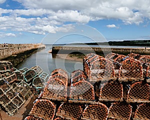 Stacks of lobster traps on a pier in Scotland