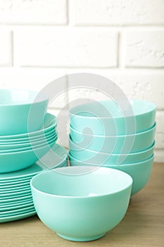 Stacks of mint ceramic dishware on light background