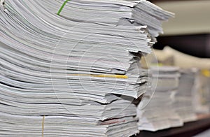 Stacks of paperwork on an office desk.