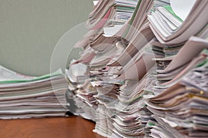 Stacks of paperwork sitting on an office desk at eye level.