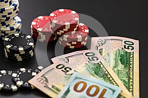 Stacks of poker chips and dollar bills on black background. Poker concept, chips and money