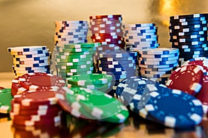 Stacks of poker chips isolated on golden background. Casino