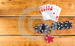 Stacks of poker chips and royal flush on wooden background, poker chips spread, big blind, dealer, poker concept