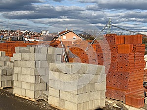 Stacks of red bricks and concrete blocks at construction supply yard. Building materials, industry, development, housing