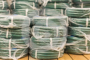 stacks of rolls yellow pvc plastic pipe on the counter in the store. Sale Hoses in the garden of various manufacturers, on shelves