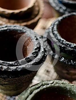 Stacks of small Mexican ceramic decorative pots with black rims