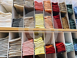 Stacks of socks yellow, pink, gray, white, neatly stacked in wardrobe departments, clothes storage organization photo