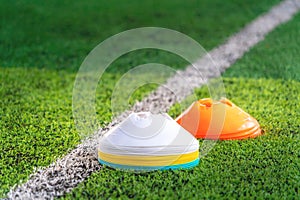 Stacks of Sport marker on training pitch with green field and white boundry line
