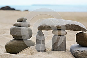 Stacks of stones on beautiful sandy beach near sea, closeup