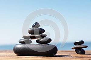 Stacks of stones on wooden pier near sea. Zen concept