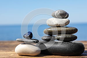 Stacks of stones on wooden pier near sea. Zen concept