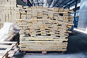 Stacks of thermal insulation fiberglass material in warehouse of sandwich panel factory