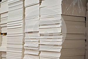 Stacks of white extruded polystyrene sheets insulative material for buildings stored in warehouse