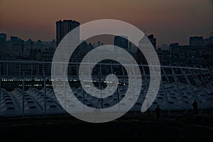 Stadium construction. Aerial view of the stadium roof on the city`s background. Sunset behind stadium for soccer