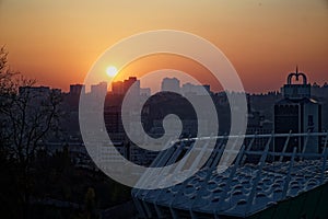 Stadium construction. Aerial view of the stadium roof on the city`s background. Sunset behind stadium for soccer