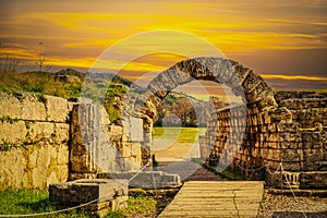 Stadium entrance  - Stone walls and arch entering the field where first olympics took place in Olympia Greece at sunset