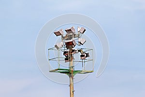 Stadium floodlight tower with reflectors with blue sky background