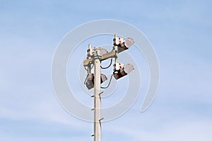 Stadium floodlight tower with reflectors with blue sky background