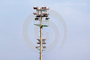 Stadium floodlight tower with reflectors with blue sky background