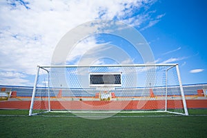 STADIUM - Football field with goal and tablo on blue sky