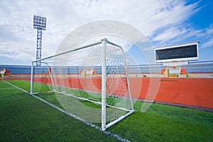 STADIUM - Football field with goal and tablo on blue sky