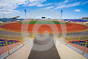 STADIUM - Football field with goal and tablo on blue sky