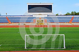 STADIUM - Football field with goal and tablo on blue sky