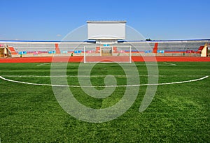 STADIUM - Football field with goal and tablo on blue sky