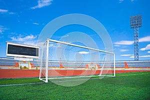 STADIUM - Football field with goal and tablo on blue sky