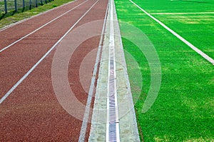 The stadium has a rubberized running track and a sports field with artificial turf. There is a drainage system between