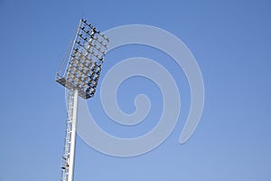 Stadium Light tower in sport arena on blue sky photo
