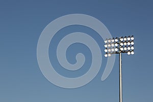 Stadium lights on a blue sky background