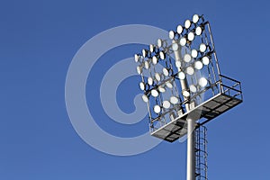 Stadium lights on a blue sky background
