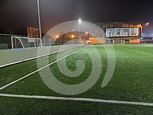 Stadium in lights and flashes. Empty beautiful football field with glowing spotlights in the evening or at night. Artificial turf