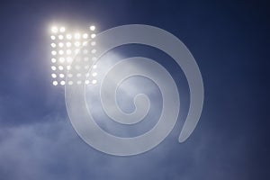 Stadium lights and smoke against dark night sky background