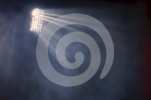 Stadium lights and smoke against dark night sky background