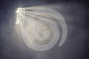 Stadium lights and smoke against dark night sky background