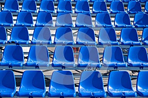 Stadium seats background. Rows of blue plastic empty chairs